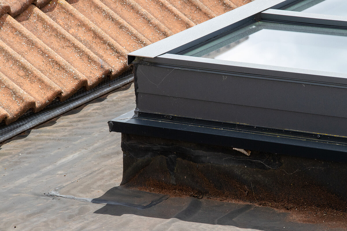 A modern skylight installation on a flat bitumen roof