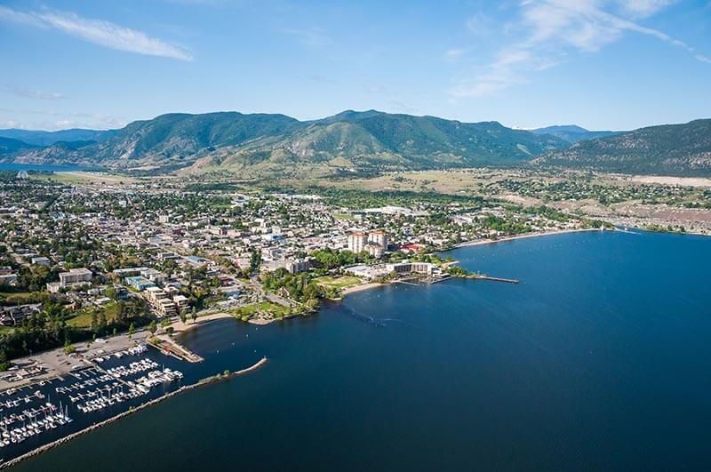 okanagan lake with penticton city on the shore and hills