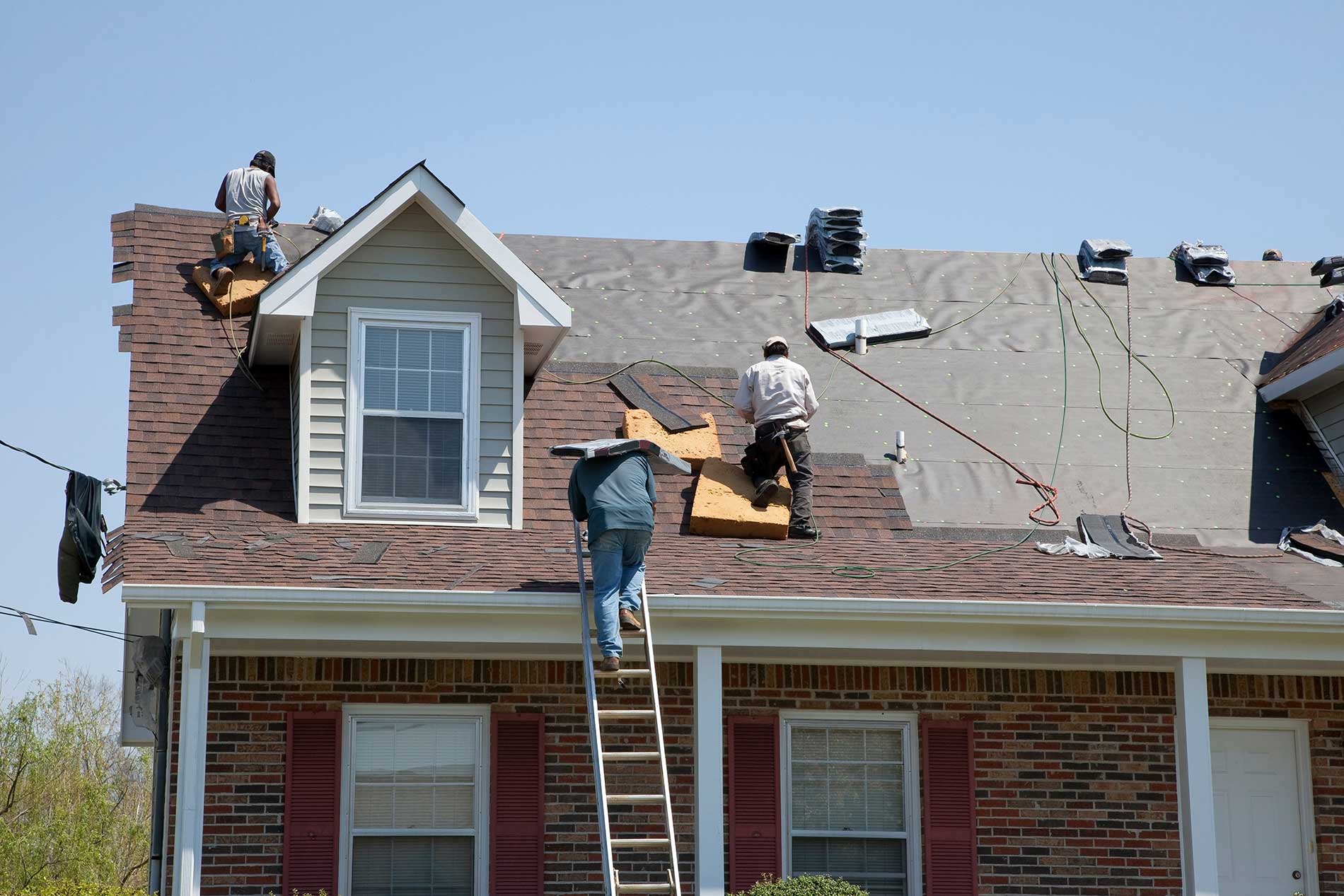 roofers working on a house replacing the roof